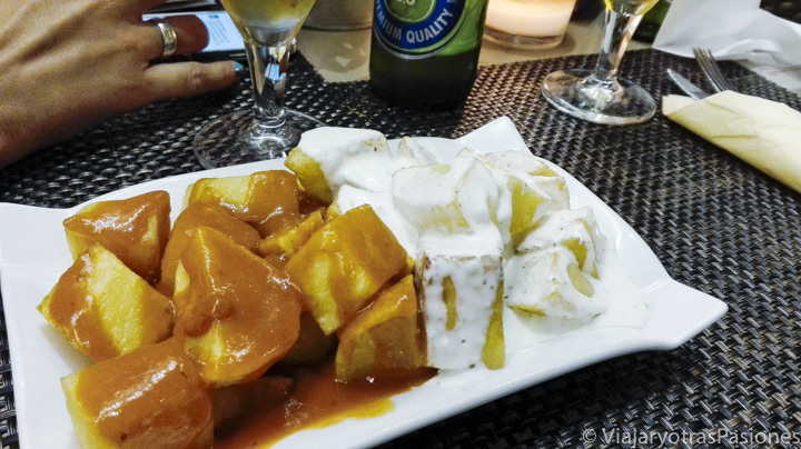 Típica tapa de patatas bravas y aioli en bar de Madrid, España