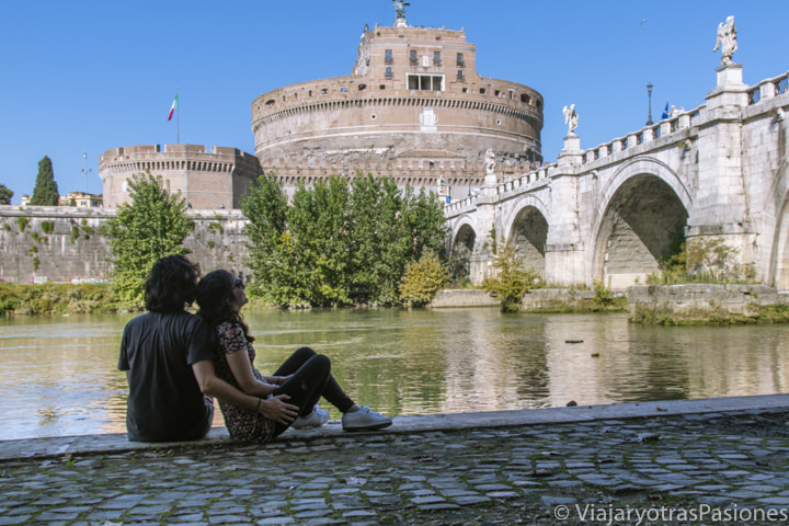 Pareja frente al famoso Castel Sant'Angelo en el centro de Roma, Italia